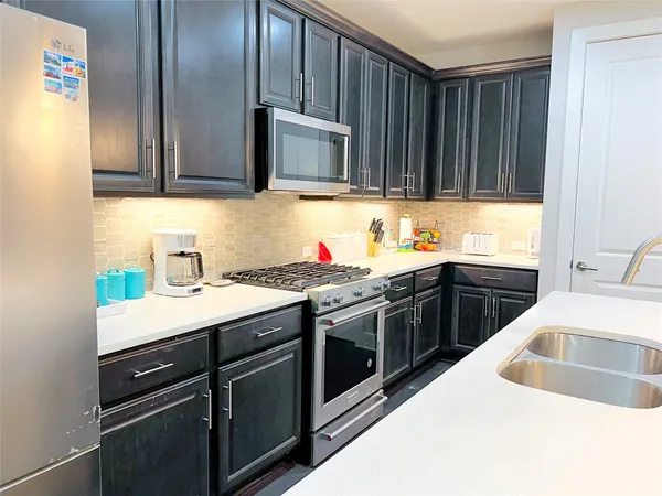 a kitchen with stainless steel appliances granite countertop a sink stove and cabinets