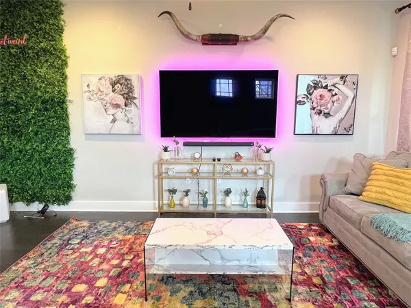 a living room with a rug and a flat screen tv