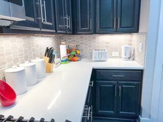 807 East 16th Street, Unit B Austin, TX 78702 - Photo 8 of 31 Kitchen with tasteful backsplash, light countertops, and dark cabinetry