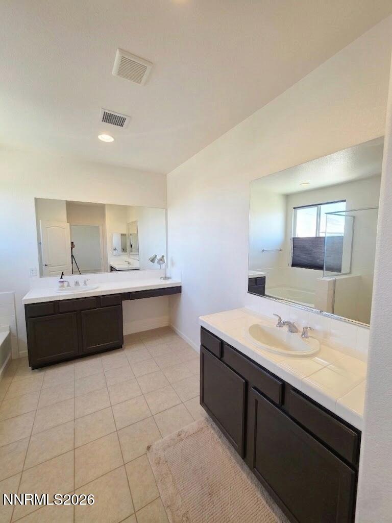2775 Bonfire Lane Reno, NV 89521 - Photo 26 of 41 a bathroom with a double vanity sink a mirror and a bathtub