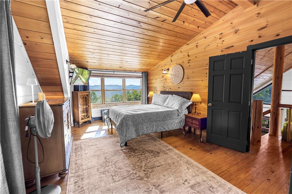 832 Scenic Mountain View Road Blue Ridge, GA 30513 - Photo 23 of 56 a bedroom with a bed and wooden floor