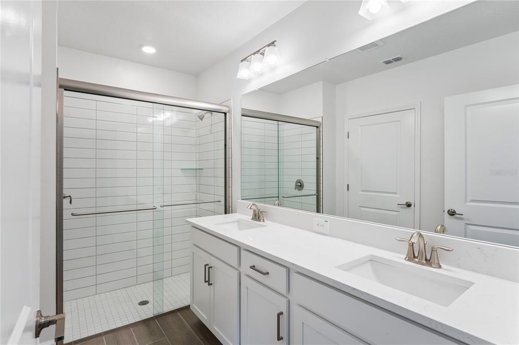 6692 Homebound Way New Port Richey, FL 34653 - Photo 23 of 47 a bathroom with a double vanity sink and mirror