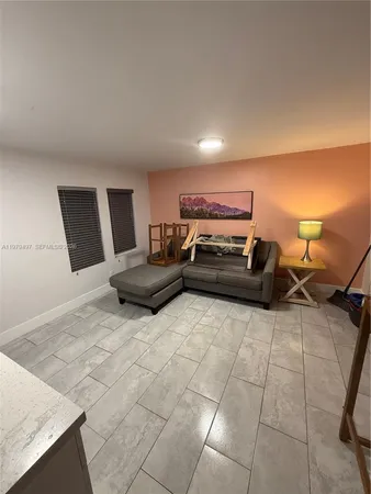 a living room with couches and kitchen view