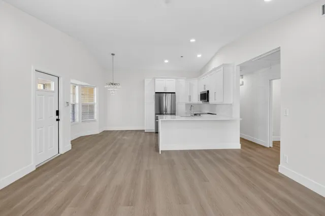 a kitchen with stainless steel appliances granite countertop a sink a stove and a refrigerator