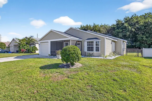 a view of a house with a yard and potted plants