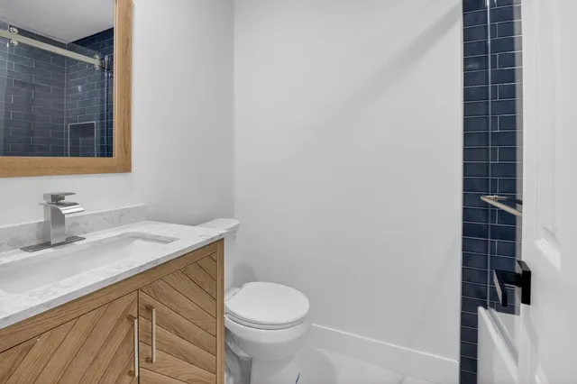 a bathroom with a sink a toilet and mirror