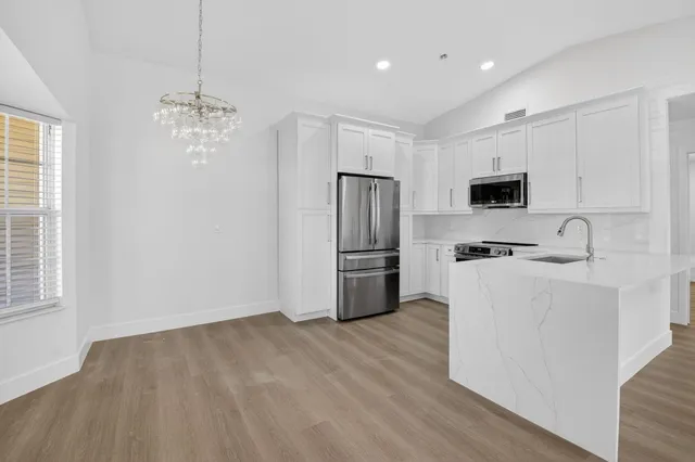 a kitchen with stainless steel appliances a refrigerator sink and microwave