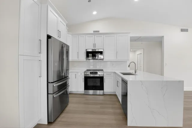 a kitchen with refrigerator a stove top oven and cabinets