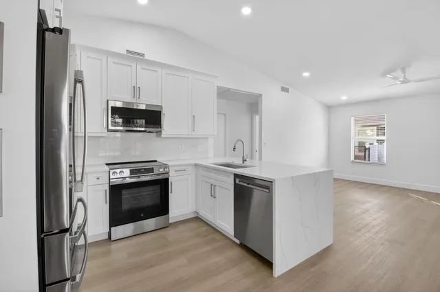 a kitchen with stainless steel appliances granite countertop a stove a refrigerator and a microwave