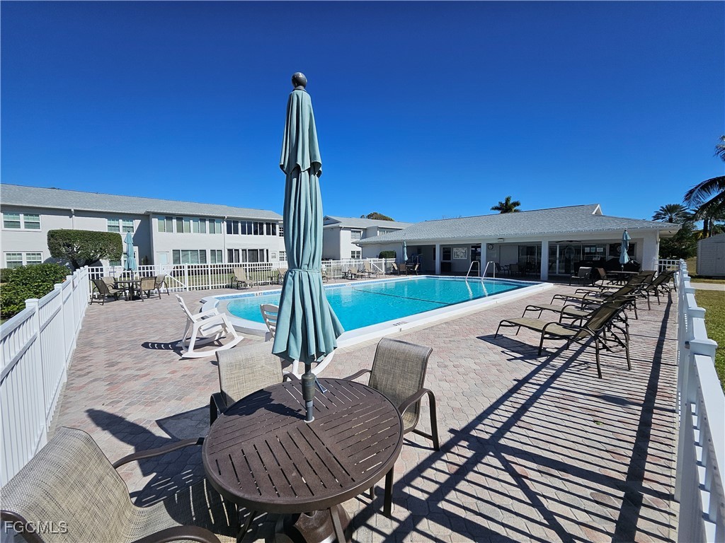 1830 Brantley Road, Unit F204 Fort Myers, FL 33907 - Photo 2 of 23 a view of a patio with couches table and chairs under an umbrella with a barbeque grill