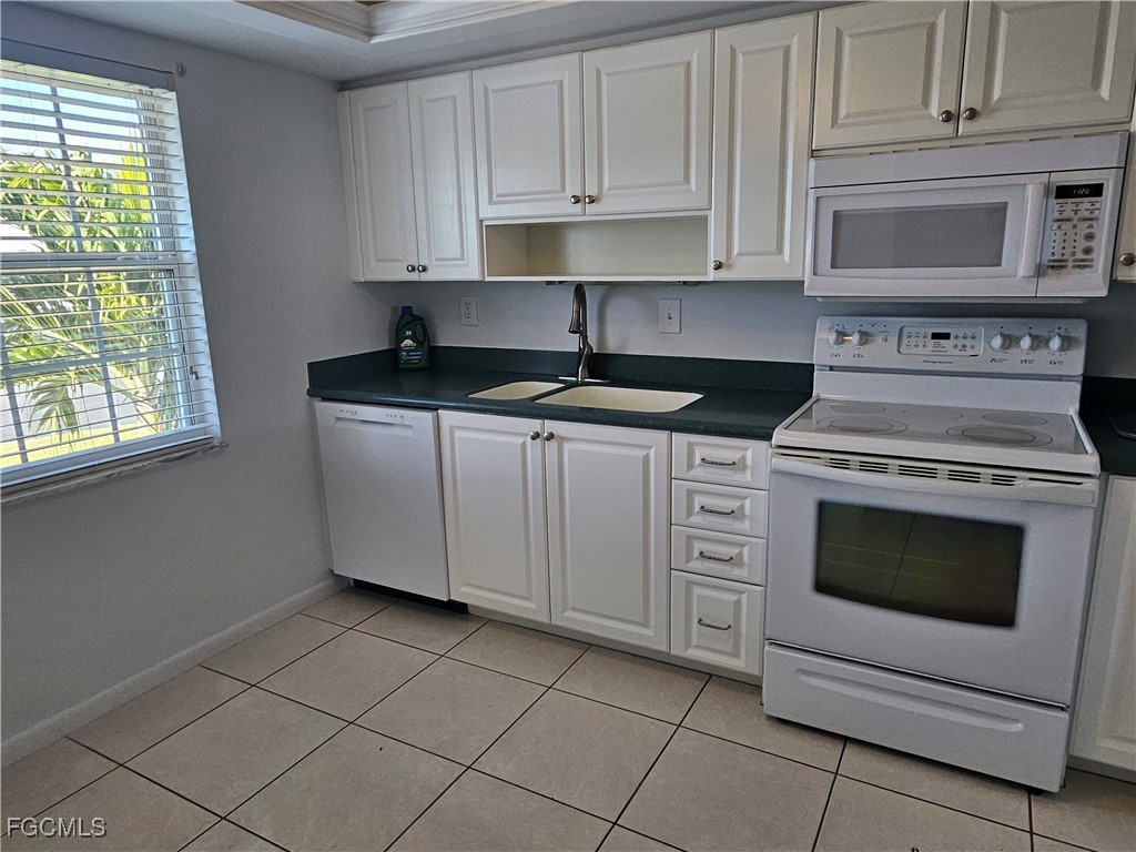 1830 Brantley Road, Unit F204 Fort Myers, FL 33907 - Photo 22 of 23 a kitchen with granite countertop white cabinets stainless steel appliances and a window