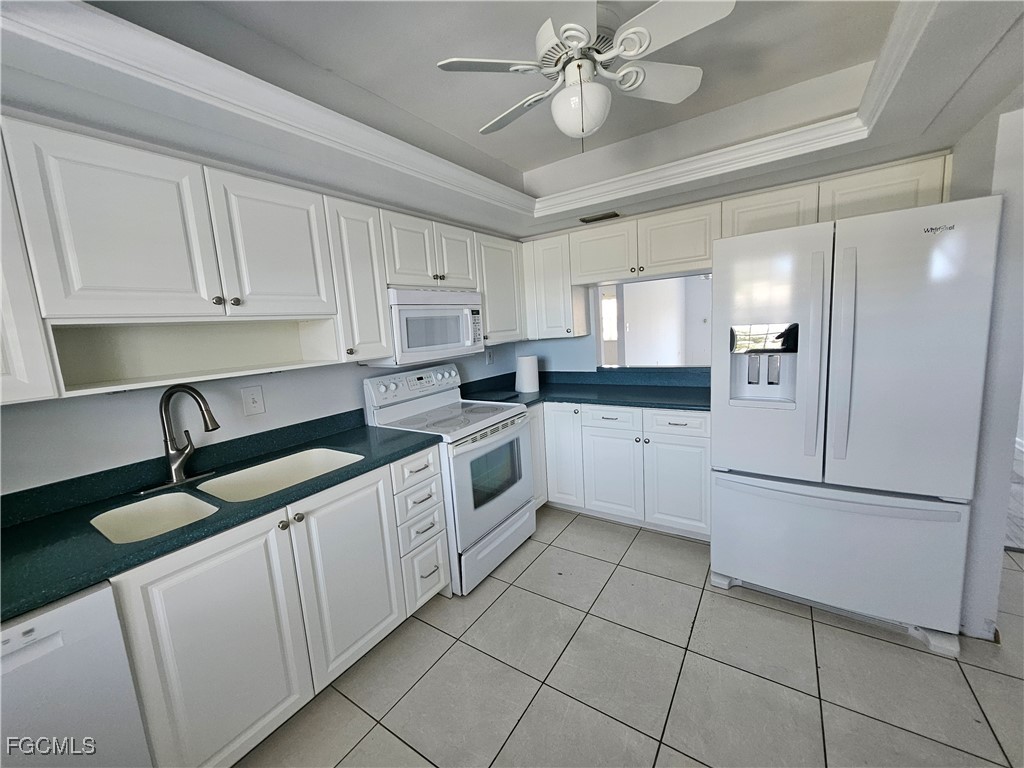 1830 Brantley Road, Unit F204 Fort Myers, FL 33907 - Photo 4 of 23 a kitchen with white cabinets and white appliances