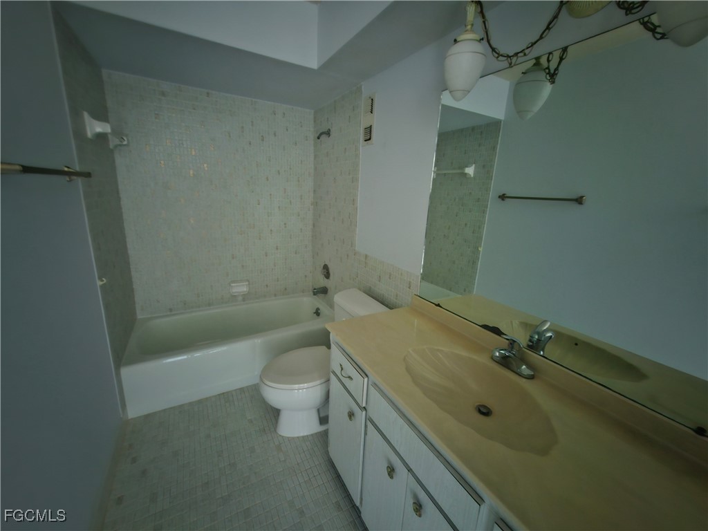 1830 Brantley Road, Unit F204 Fort Myers, FL 33907 - Photo 8 of 23 a bathroom with a granite countertop sink a toilet and shower