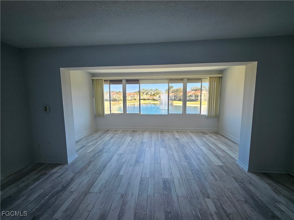 1830 Brantley Road, Unit F204 Fort Myers, FL 33907 - Photo 9 of 23 an empty room with wooden floor and windows