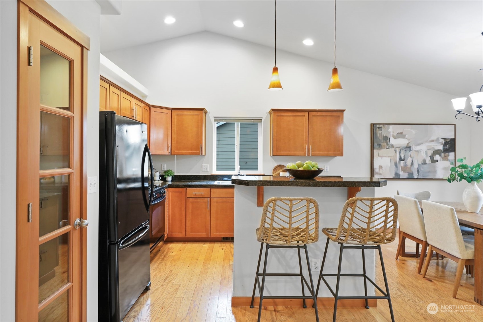 910 209th Street Southeast Bothell, WA 98021 - Photo 13 of 28 a kitchen with stainless steel appliances granite countertop a refrigerator a sink dishwasher a dining table and chairs with wooden floor