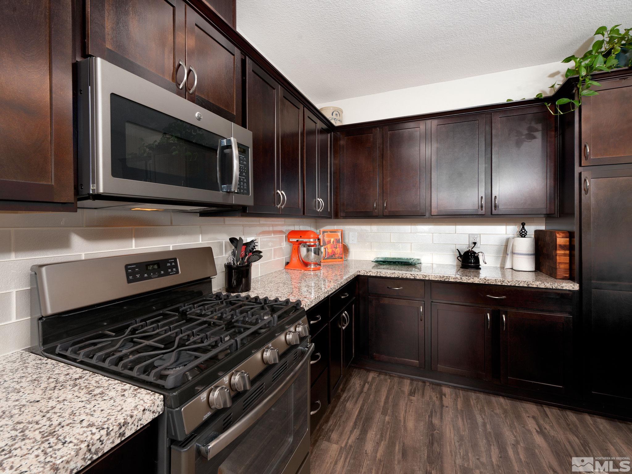 1970 Dark Horse Road, Unit C Reno, NV 89521 - Photo 10 of 35 a kitchen with stainless steel appliances kitchen island granite countertop a stove a sink and a microwave