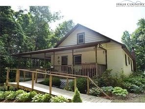 a view of a house with wooden deck and furniture