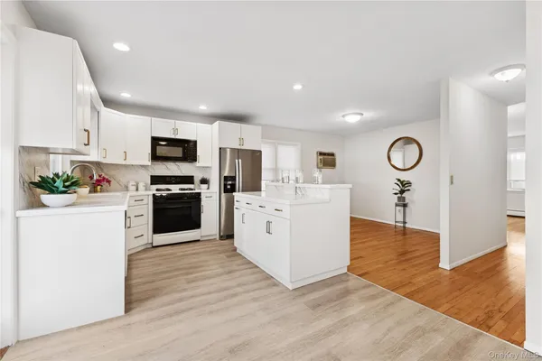 a kitchen with white cabinets and stainless steel appliances