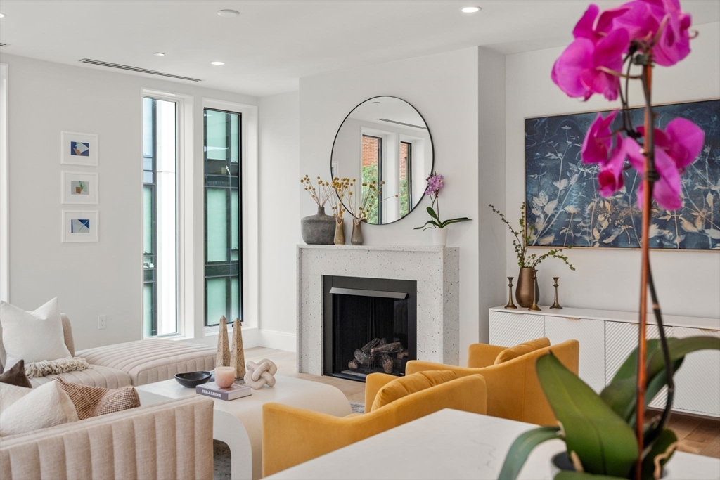 a living room with furniture a fireplace and a potted plant