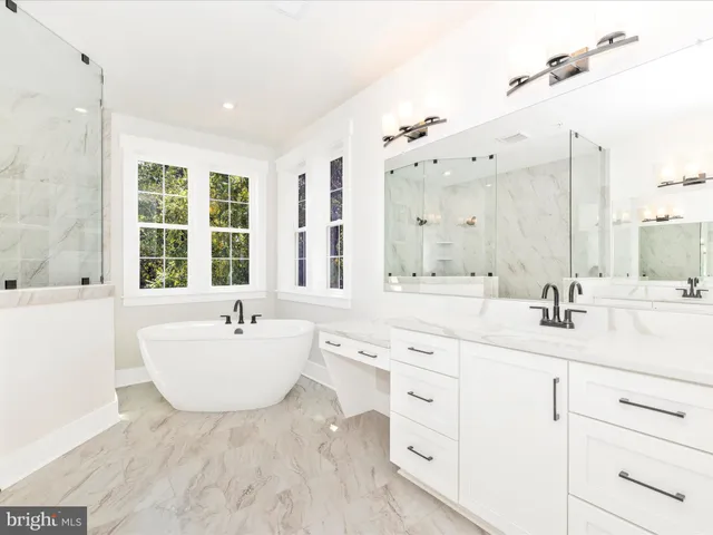 a bathroom with a sink double vanity mirror and bathtub