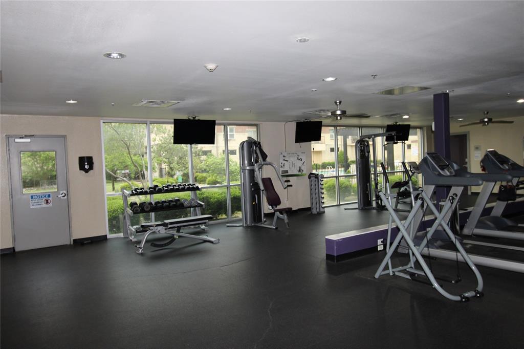 1100 West Trinity Mills Road, Unit 3035 Carrollton, TX 75006 - Photo 4 of 12 a room with gym equipment and wooden floor