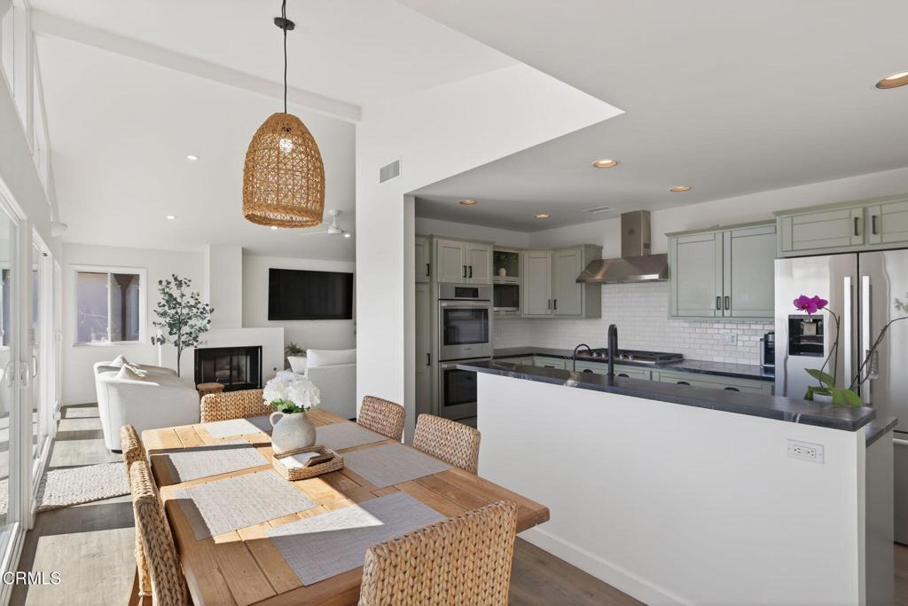 4229 Faria Road Ventura, CA 93001 - Photo 15 of 47 a kitchen with stainless steel appliances granite countertop a stove a microwave a refrigerator a sink dishwasher a dining table and chairs with the living room view