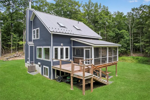 a view of a house with a yard deck and a garden