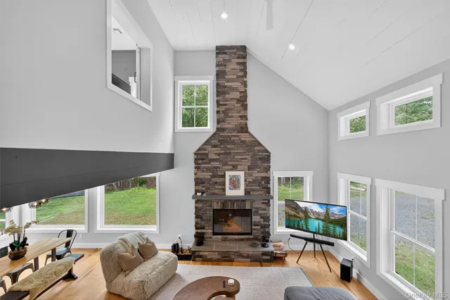 a living room with furniture fireplace and large windows