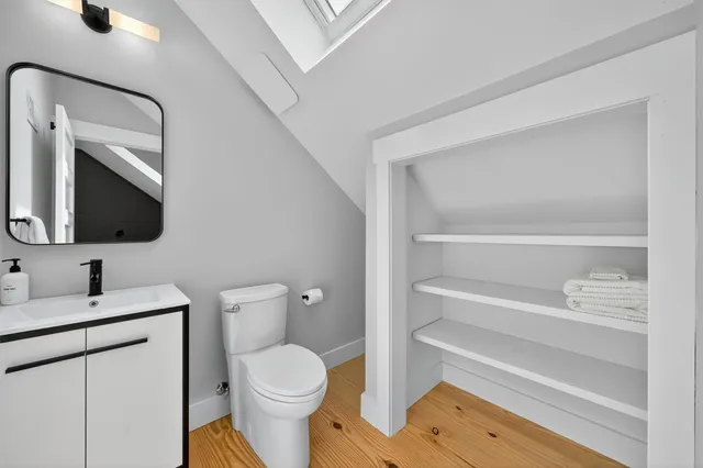 a bathroom with a toilet sink and mirror