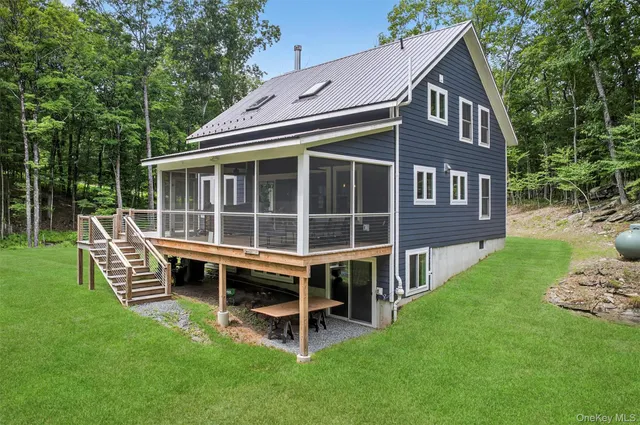 a view of backyard with green space and wooden fence