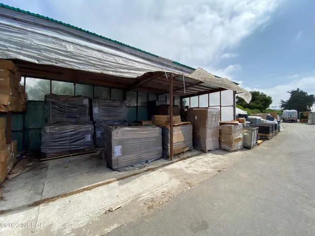 a view of a patio with table and chairs under an umbrella