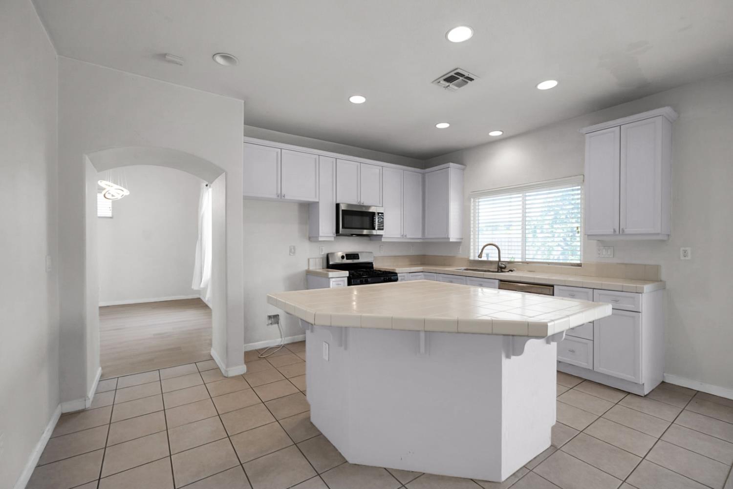 1412 Red Ribbons Lane Manteca, CA 95337 - Photo 9 of 32 a kitchen with kitchen island a sink stainless steel appliances and cabinets