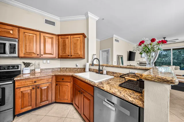 a kitchen with stainless steel appliances granite countertop a sink stove and cabinets