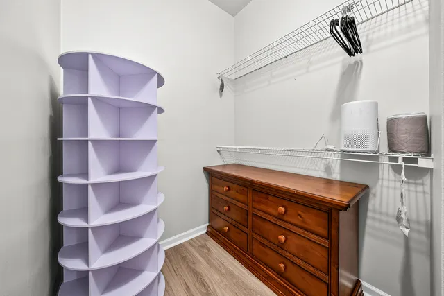 a room with a walk in closet and wooden floor