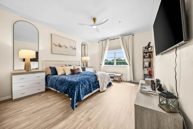 a spacious bedroom with a bed and wooden floor