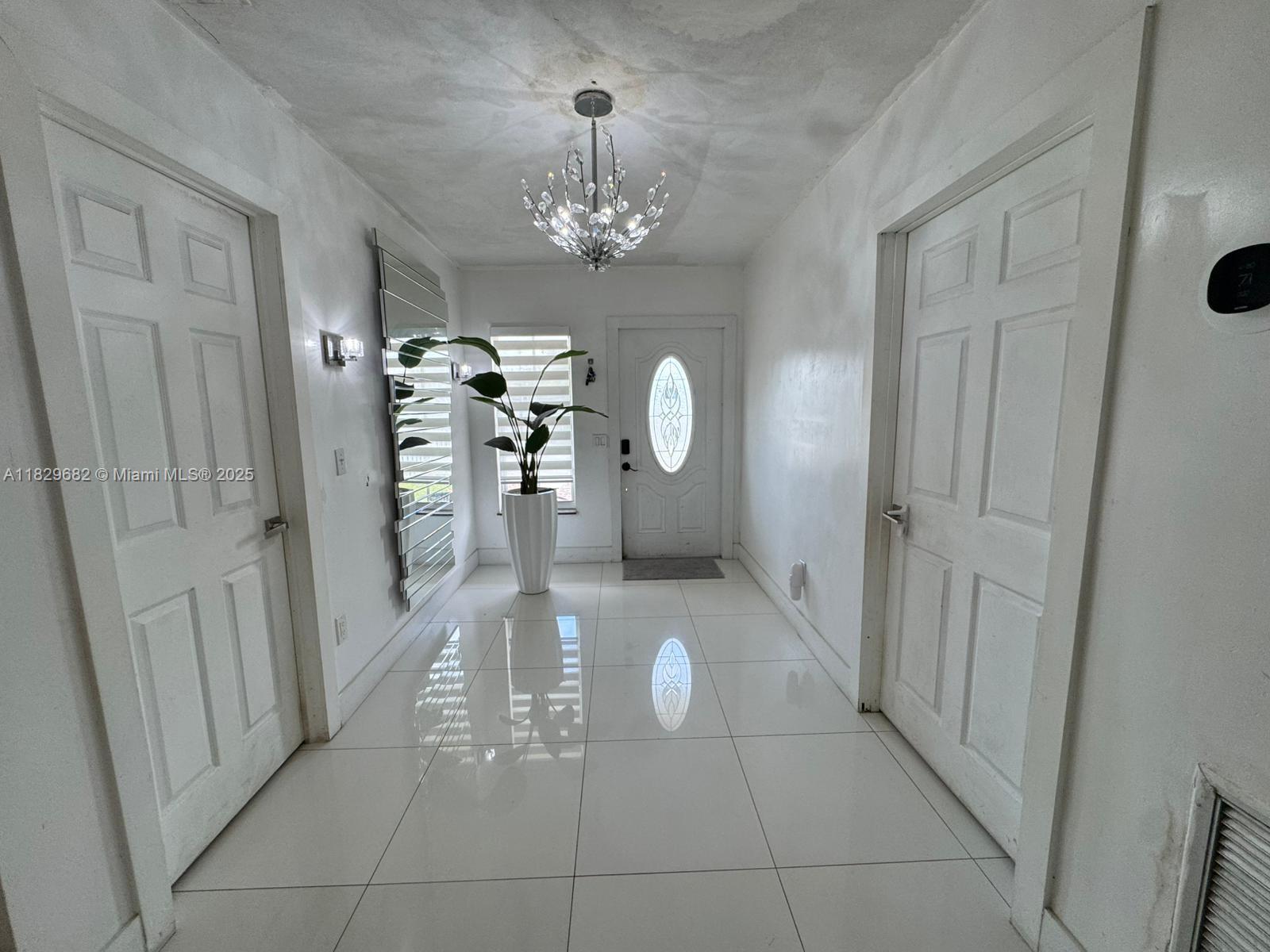 12841 Southwest 54th Street, Unit 1 Miami, FL 33175 - Photo 2 of 15 a view of a hallway with a chandelier