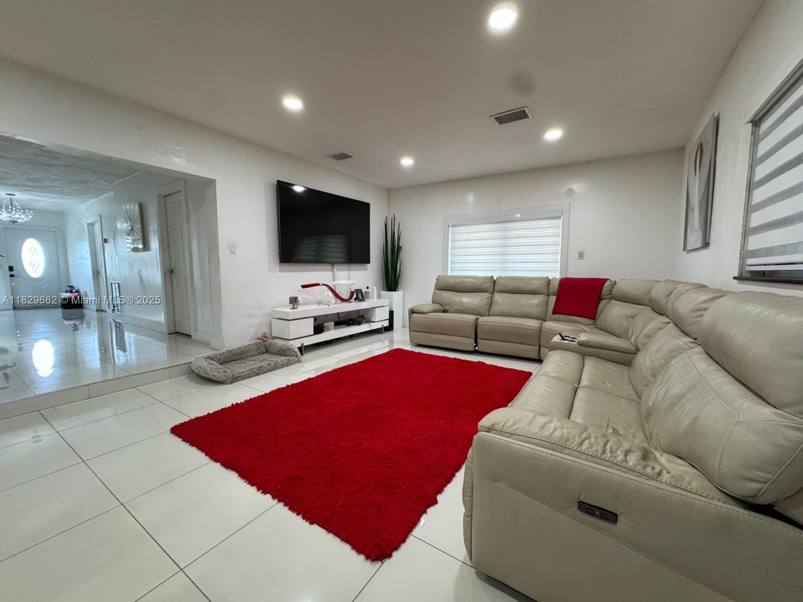 12841 Southwest 54th Street, Unit 1 Miami, FL 33175 - Photo 7 of 15 a living room with furniture and a flat screen tv