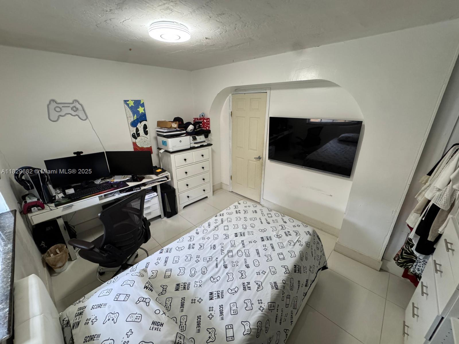 12841 Southwest 54th Street, Unit 1 Miami, FL 33175 - Photo 9 of 15 a bedroom with a bed and a flat screen tv