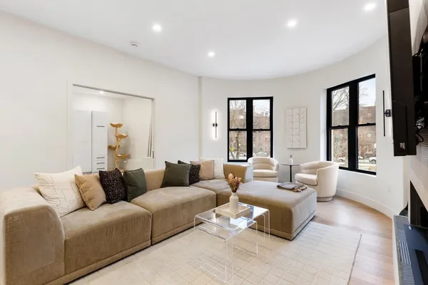 a living room with furniture and large windows