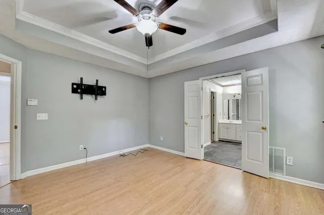 wooden floor in an empty room with a chandelier fan