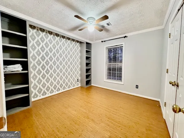 a view of an empty room with a window and closet