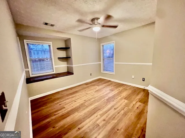 a view of empty room with wooden floor