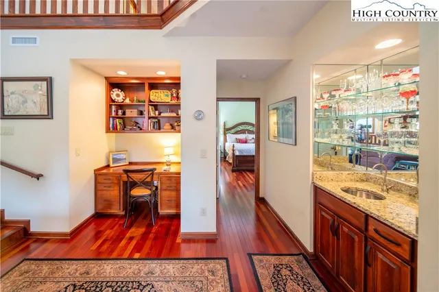 a hallway view with furniture and wooden floor