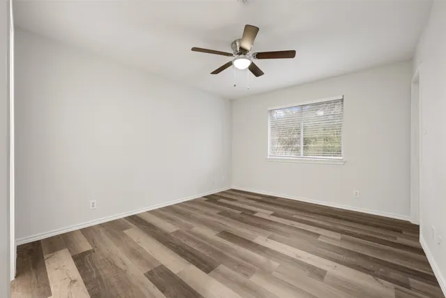 a view of a big room with wooden floor and windows