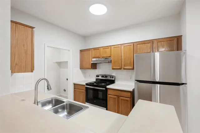 a kitchen with a refrigerator sink and white cabinets