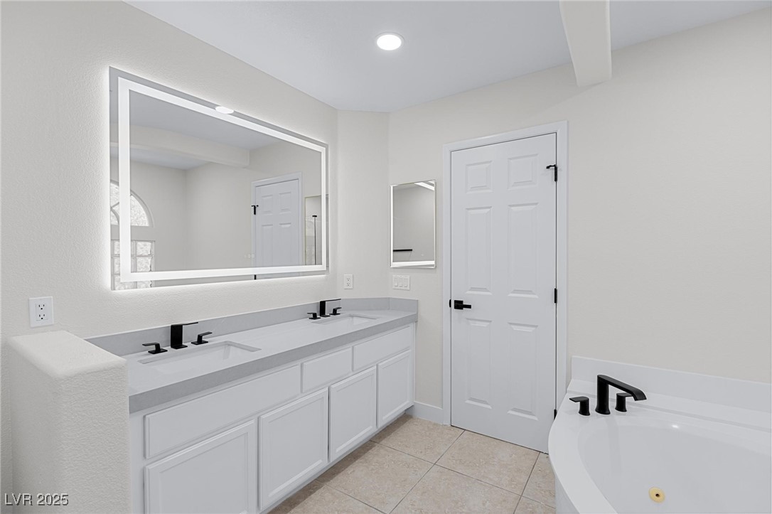 9591 Antelope Bend Court Las Vegas, NV 89148 - Photo 32 of 56 Full bath with double vanity, a bath, light tile patterned floors, and recessed lighting