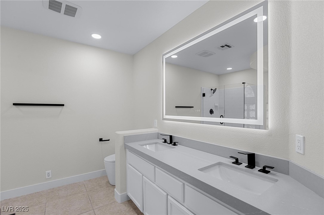 9591 Antelope Bend Court Las Vegas, NV 89148 - Photo 33 of 56 Full bath with a shower stall, double vanity, light tile patterned floors, and recessed lighting