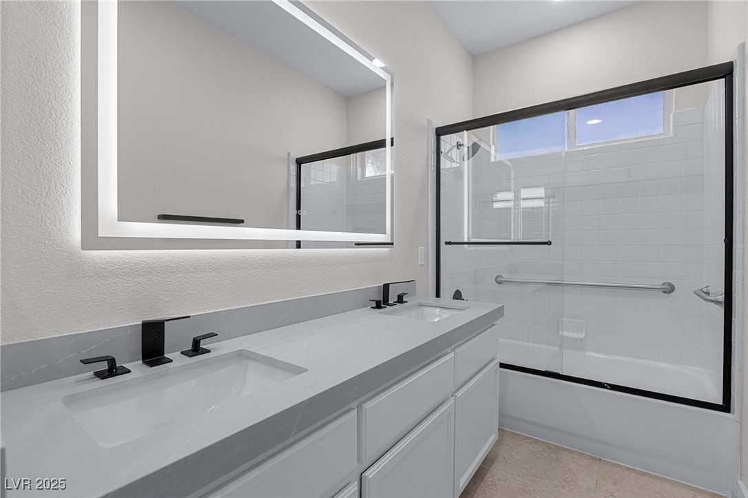 9591 Antelope Bend Court Las Vegas, NV 89148 - Photo 42 of 56 Full bathroom featuring enclosed tub / shower combo, double vanity, a textured wall, and light tile patterned floors