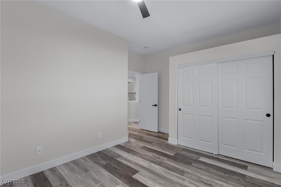 9591 Antelope Bend Court Las Vegas, NV 89148 - Photo 45 of 56 Unfurnished bedroom featuring a closet, dark wood finished floors, and ceiling fan with light