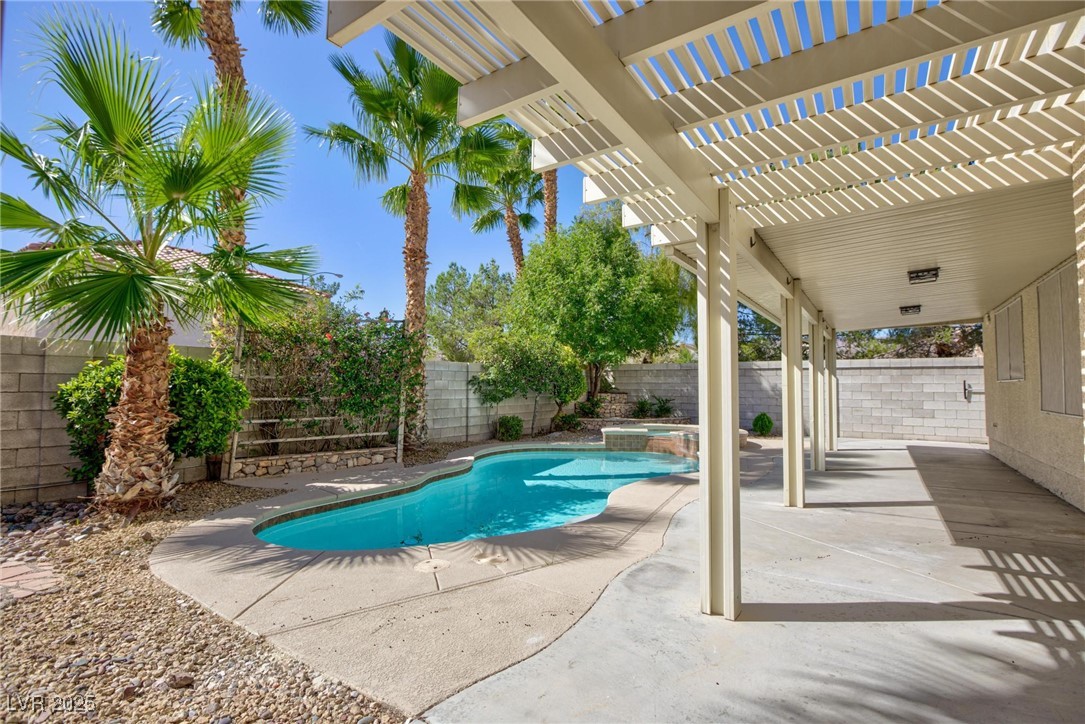 9591 Antelope Bend Court Las Vegas, NV 89148 - Photo 50 of 56 View of swimming pool with a pergola, a patio, a fenced backyard, and a pool with connected hot tub
